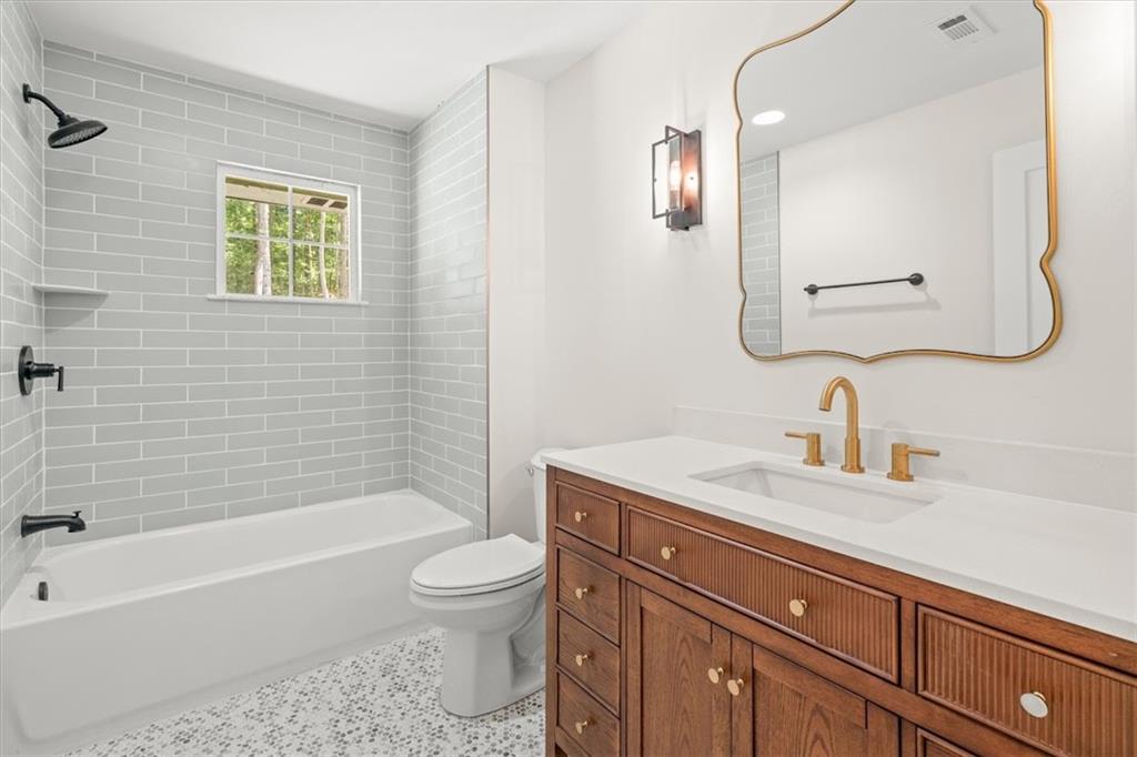 2237 Clem Lowell Road Carrollton, GA 30116 - Photo 19 of 60 a bathroom with a granite countertop toilet a sink a mirror and bathtub