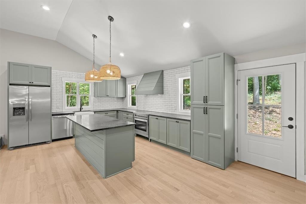 2237 Clem Lowell Road Carrollton, GA 30116 - Photo 5 of 60 a kitchen with stainless steel appliances granite countertop a sink a refrigerator and a wooden floor