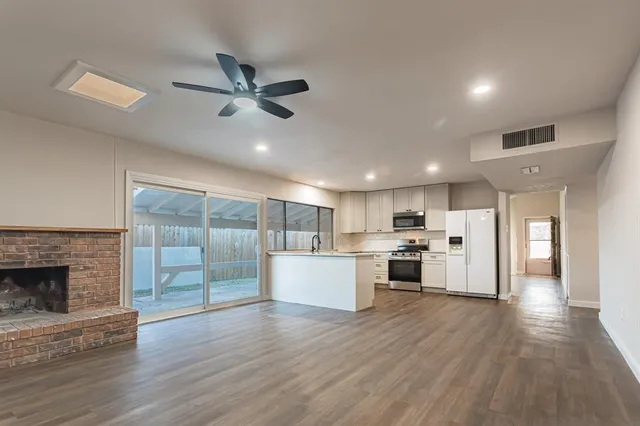 a view of a yard with plants and a large tree