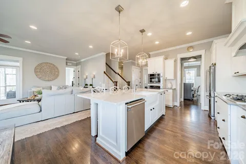 a large kitchen with stainless steel appliances kitchen island granite countertop a sink and cabinets