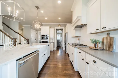 a large kitchen with kitchen island lots of counter space a sink appliances and cabinets
