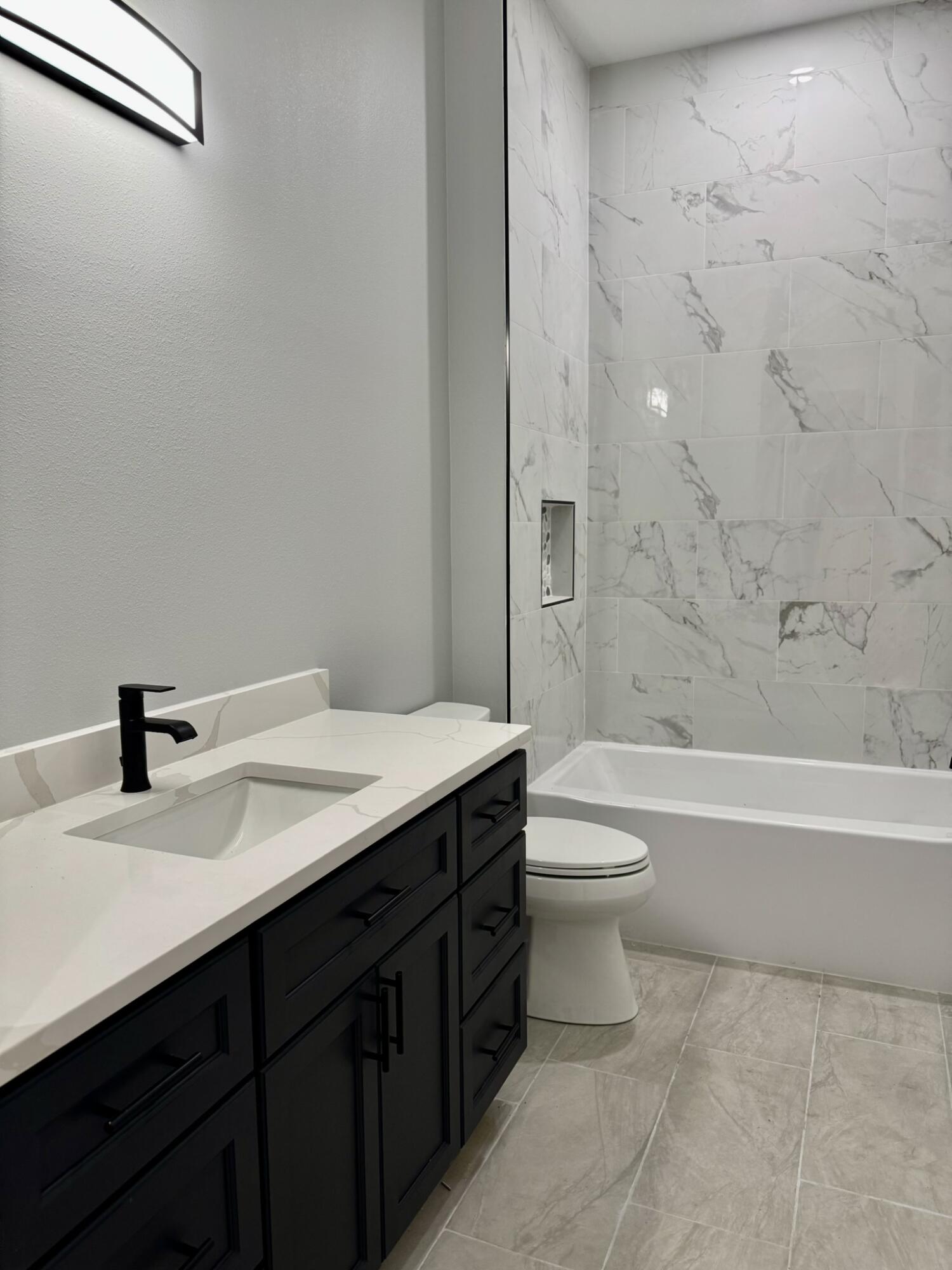 13200 Highway 441 Okeechobee, FL 34974 - Photo 24 of 42 a bathroom with a granite countertop sink toilet a large mirror and bathtub