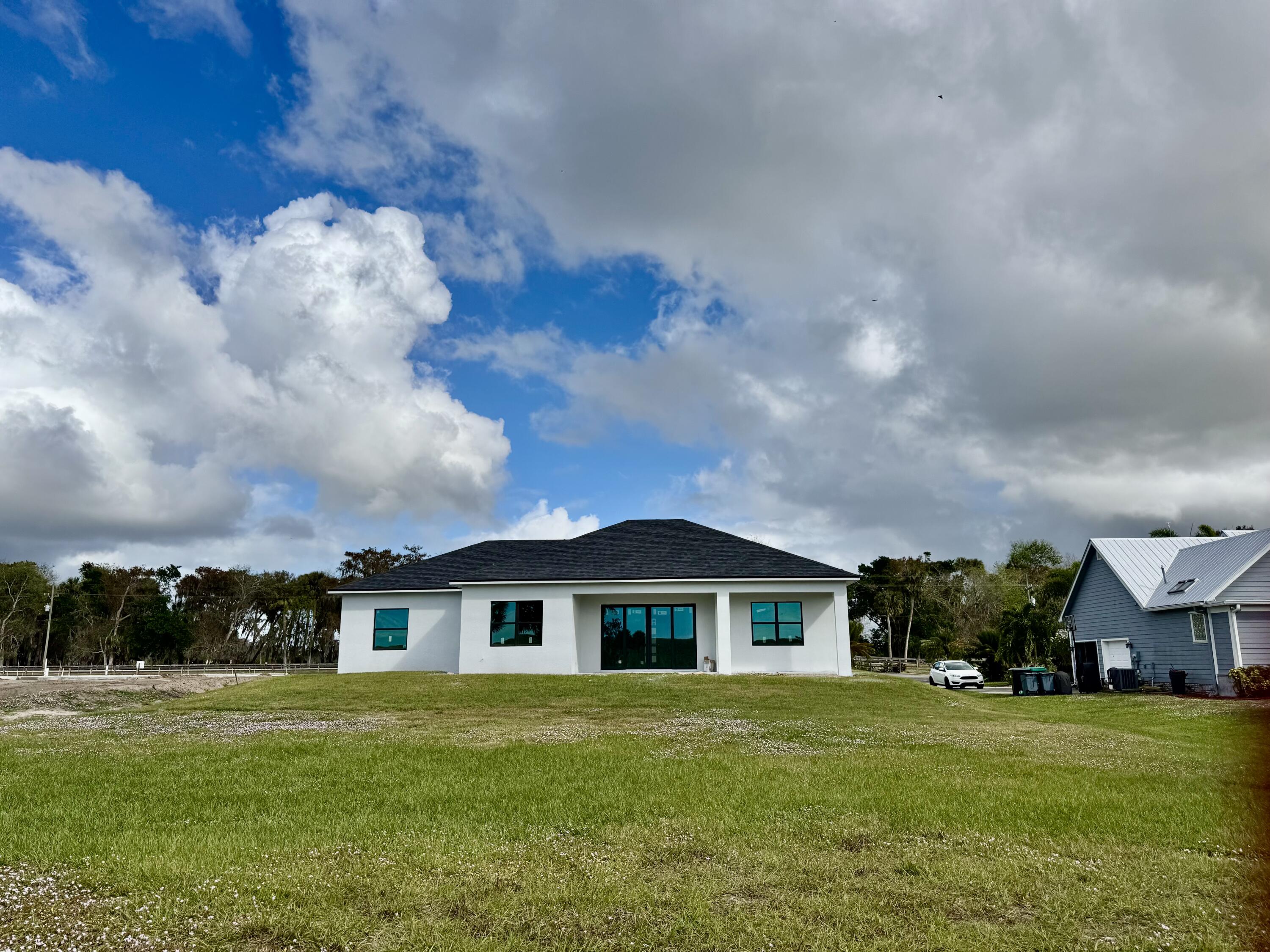 13200 Highway 441 Okeechobee, FL 34974 - Photo 3 of 42 a front view of a house with a garden