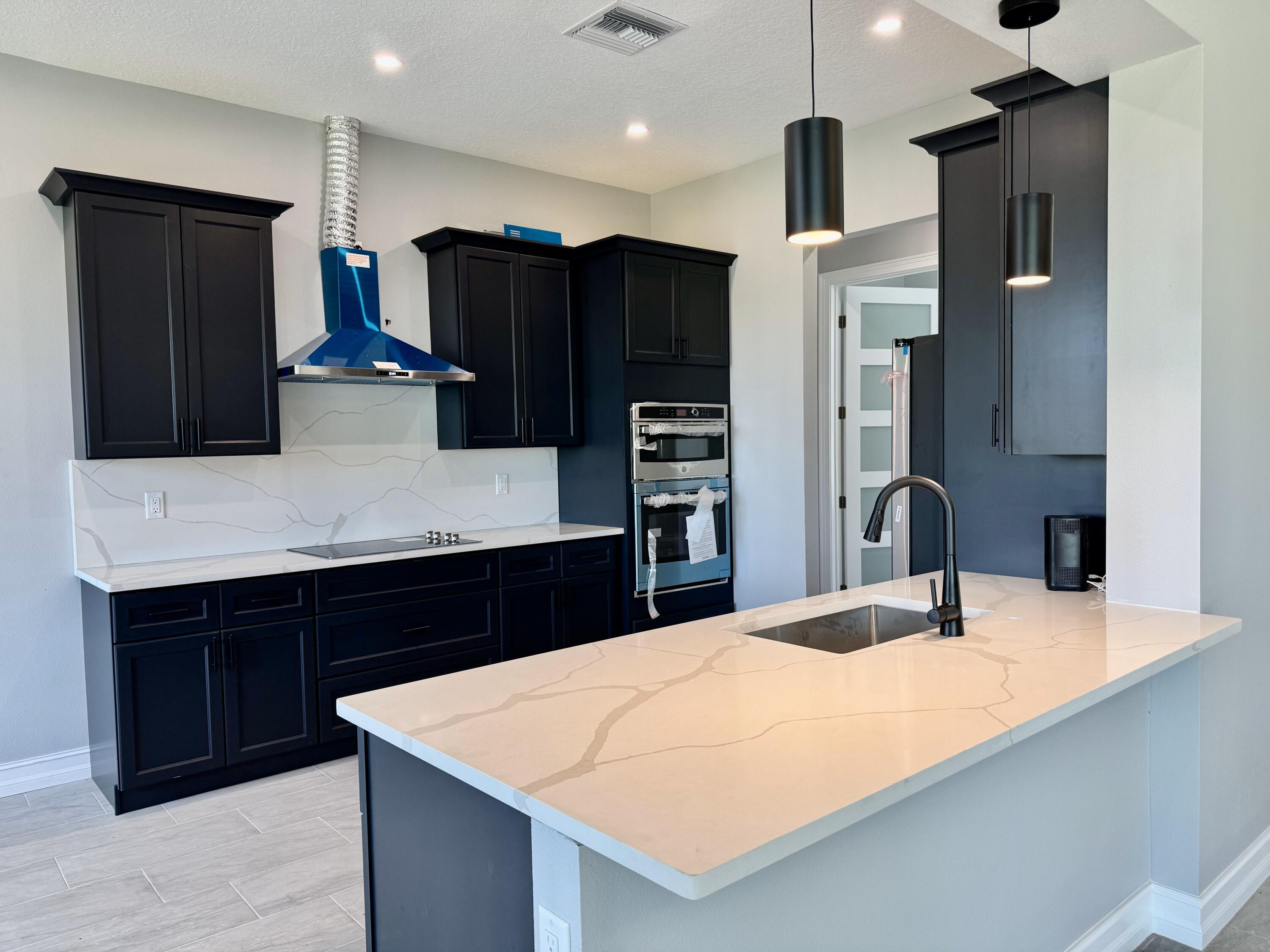 13200 Highway 441 Okeechobee, FL 34974 - Photo 7 of 42 a kitchen with stainless steel appliances kitchen island a refrigerator and a sink