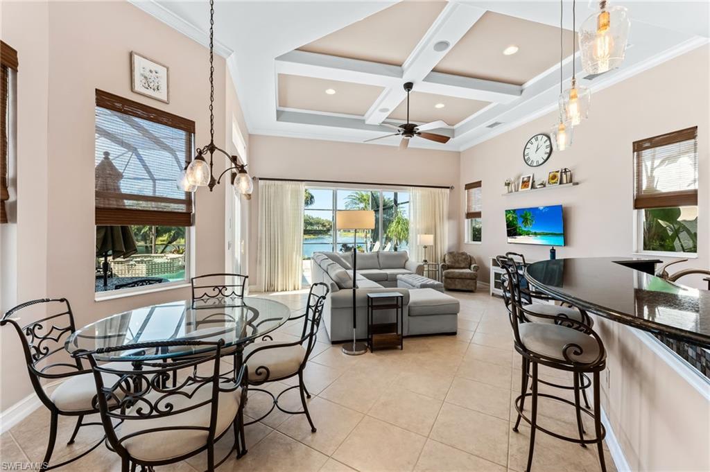 7875 Valencia Court Naples, FL 34113 - Photo 11 of 38 Dining room with coffered ceiling, a ceiling fan, light tile patterned floors, crown molding, and a chandelier