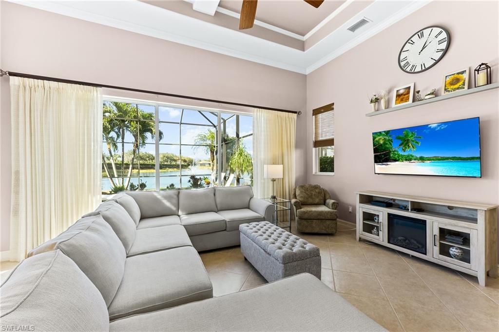 7875 Valencia Court Naples, FL 34113 - Photo 13 of 38 Living room with ceiling fan, light tile patterned floors, ornamental molding and a raised ceiling