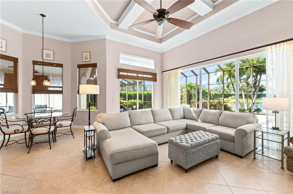 7875 Valencia Court Naples, FL 34113 - Photo 14 of 38 Living room featuring a high ceiling, light tile patterned flooring, ornamental molding, ceiling fan, and suspended lighting