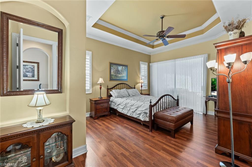 7875 Valencia Court Naples, FL 34113 - Photo 16 of 38 Bedroom with wood flooring, a tray ceiling, ornamental molding, and ceiling fan