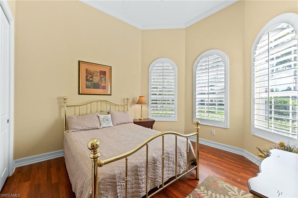 7875 Valencia Court Naples, FL 34113 - Photo 21 of 38 Bedroom featuring wood flooring, ornamental molding, and a closet