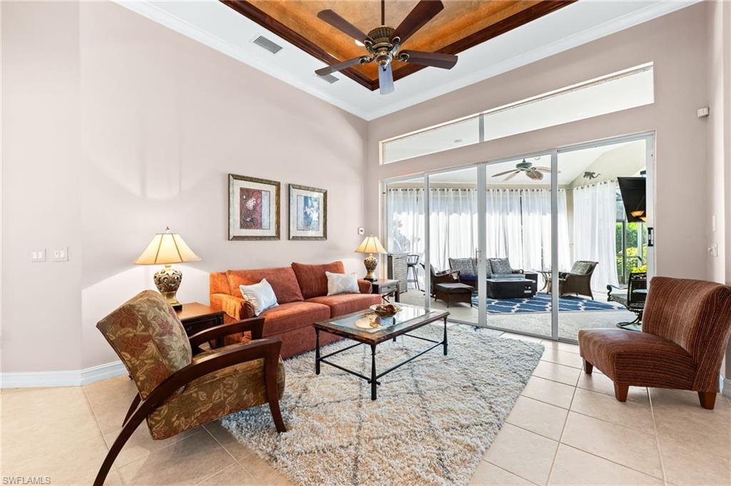 7875 Valencia Court Naples, FL 34113 - Photo 5 of 38 Living area featuring a raised ceiling, a ceiling fan, crown molding, and light tile patterned floors