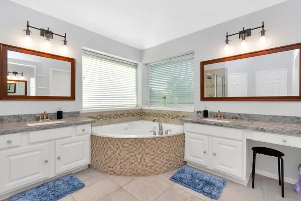 a spacious bathroom with a granite countertop tub sink and mirror