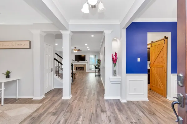a view of a hallway with wooden floor and staircase