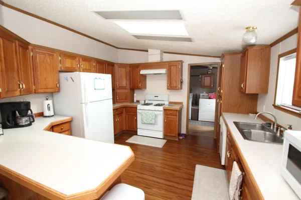 a kitchen with a sink a refrigerator and wooden floor