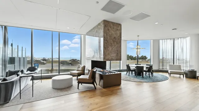 a living room with furniture large windows and view of backyard