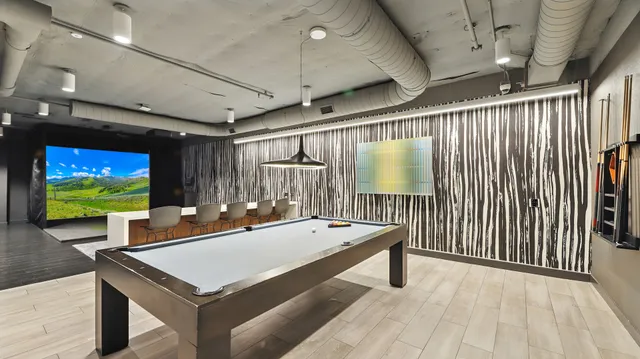 a room with pool table and windows
