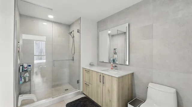 a bathroom with a bathtub shower sink mirror and toilet