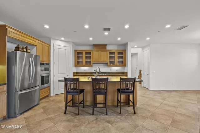 a kitchen with a dining table chairs and cabinets
