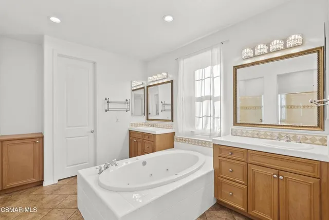 a bathroom with a bathtub sink and mirror