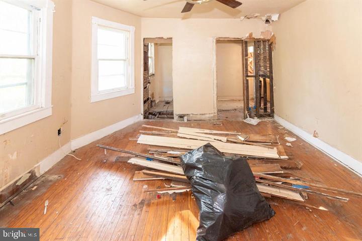 3900 5th Street Baltimore, MD 21225 - Photo 25 of 32 a view of a bedroom with wooden floor and a window