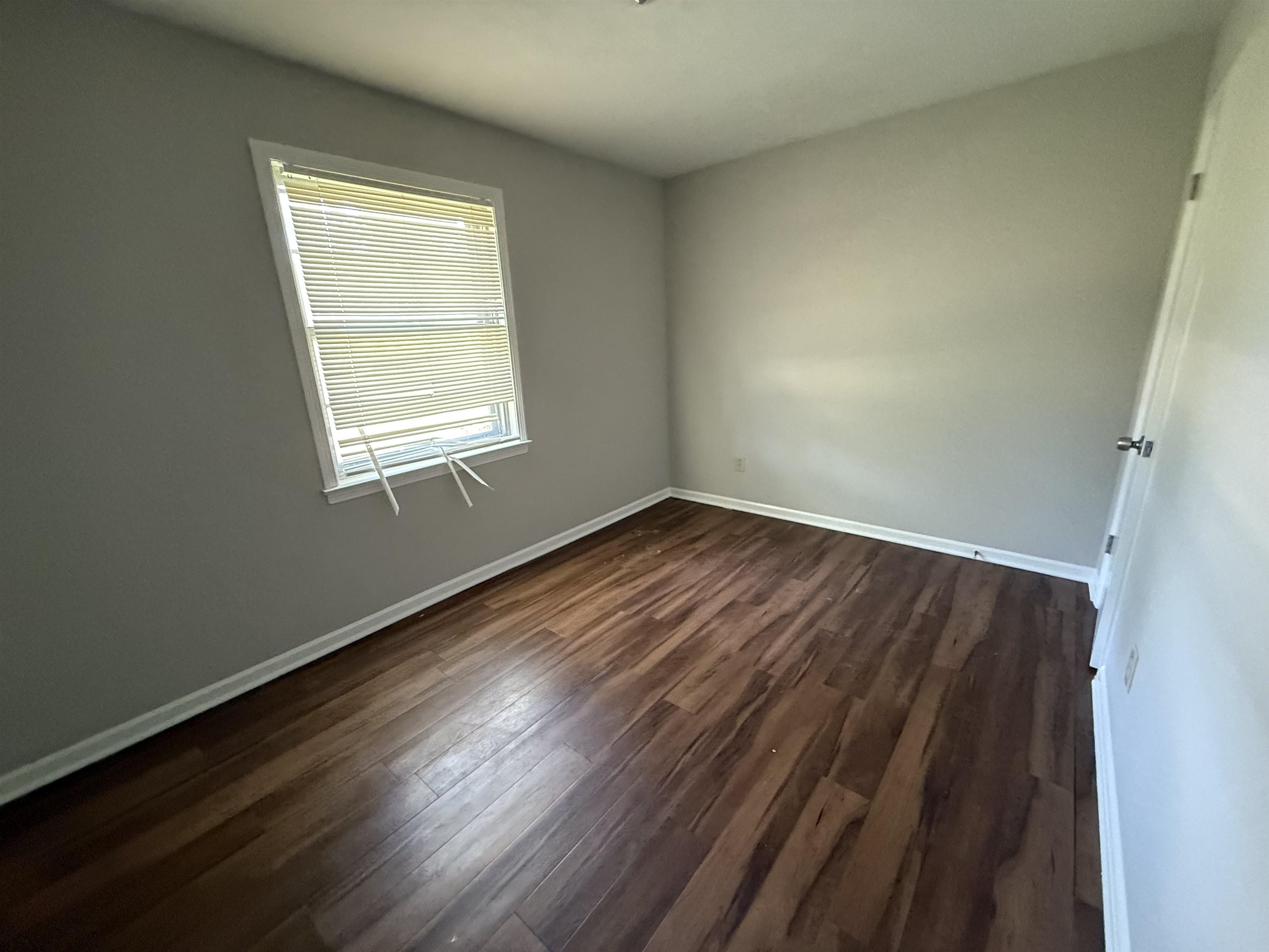 4592 Neely Road Memphis, TN 38109 - Photo 6 of 8 an empty room with wooden floor and windows