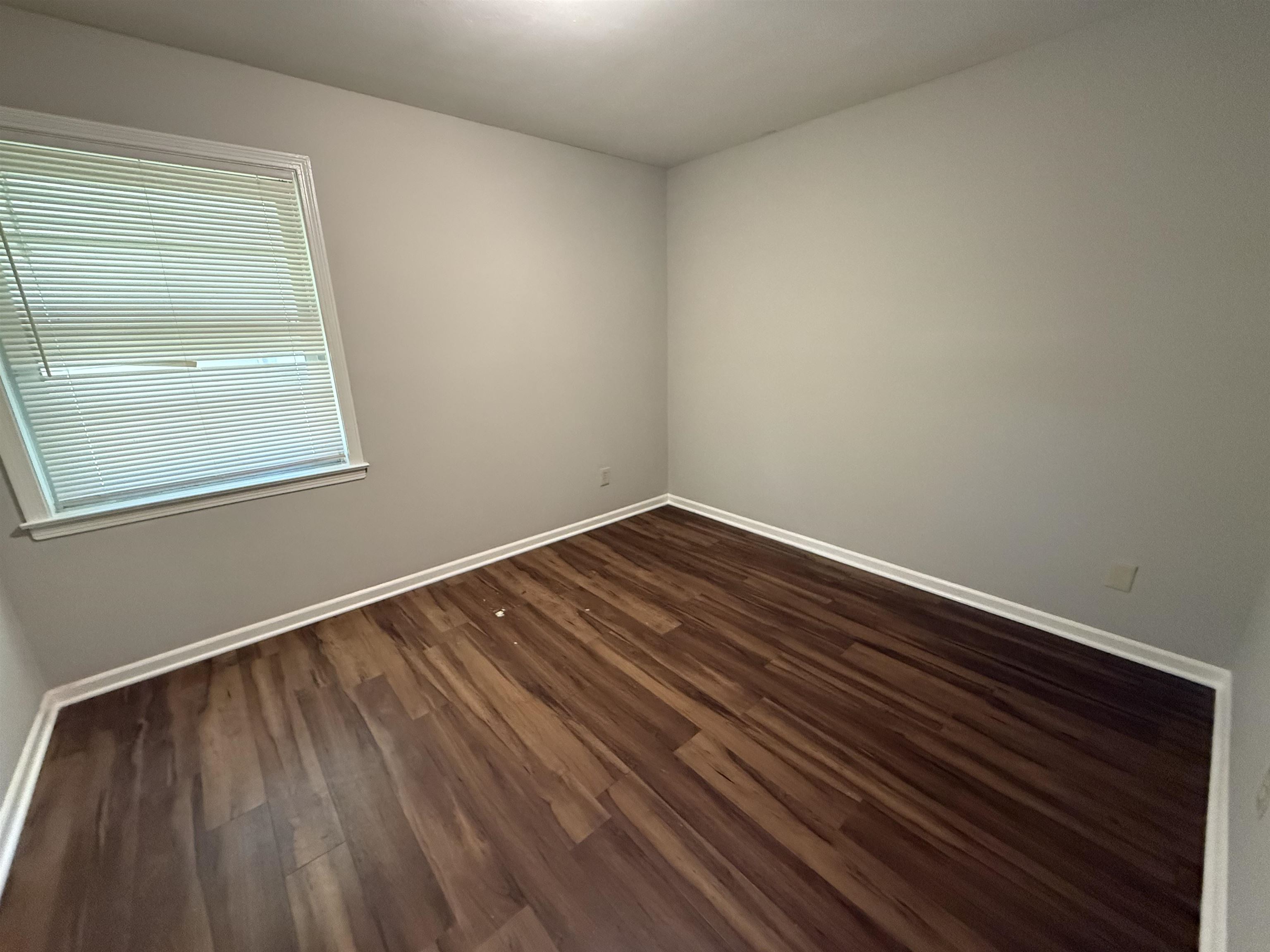 4592 Neely Road Memphis, TN 38109 - Photo 8 of 8 a view of an empty room with wooden floor and a window