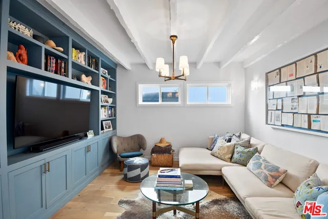 a living room with furniture a flat screen tv and a window