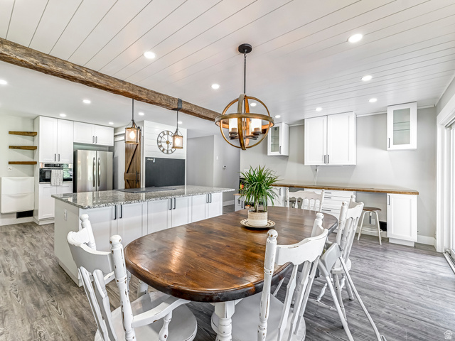 523 South Main Street Payson, UT 84651 - Photo 15 of 41 Open-concept kitchen and dining area featuring a shiplap ceiling with recessed lighting, an exposed wood beam, and wood-finish flooring