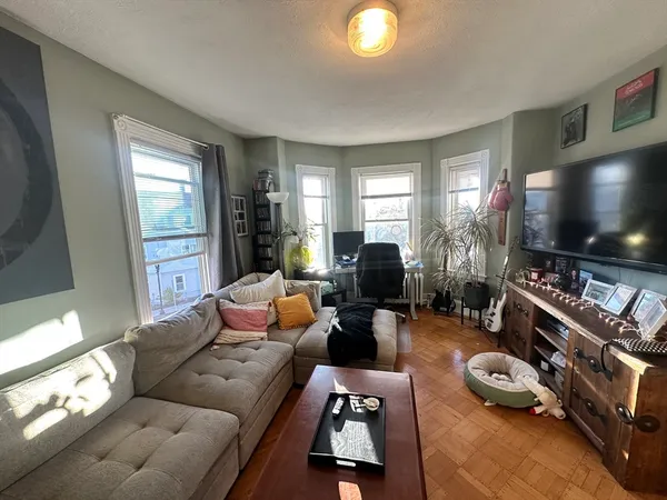 a living room with furniture a window and a flat screen tv