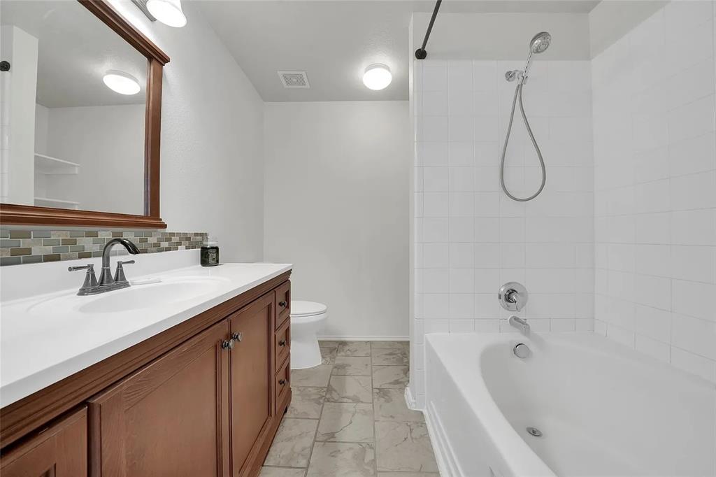 713 Baldwin Road Wylie, TX 75098 - Photo 13 of 29 a bathroom with a granite countertop sink a toilet and shower