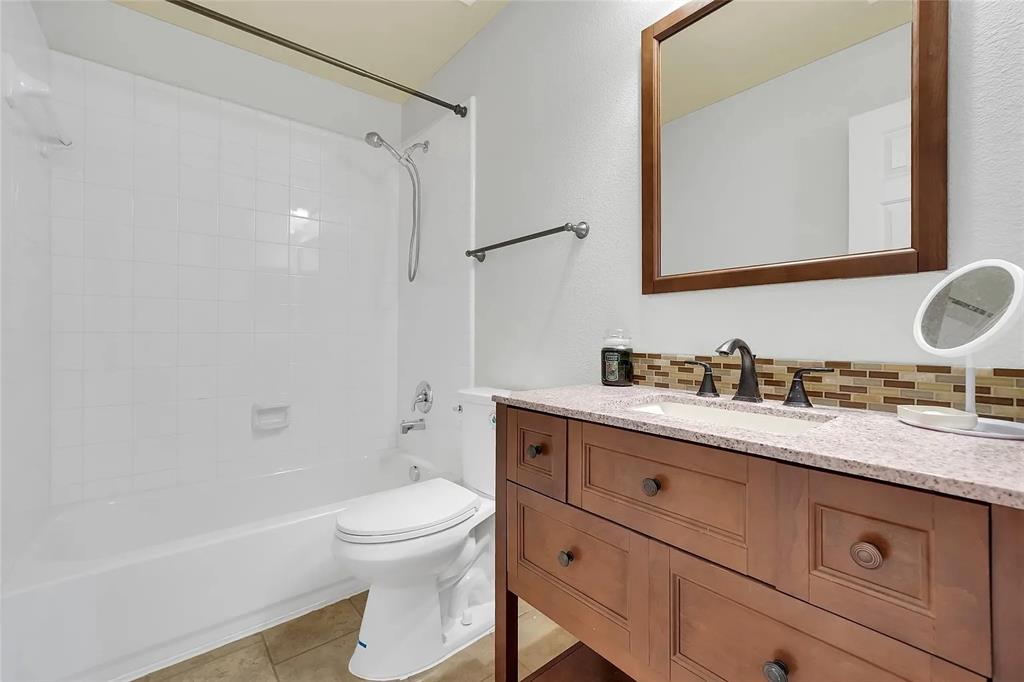 713 Baldwin Road Wylie, TX 75098 - Photo 17 of 29 a bathroom with a granite countertop sink toilet a shower and a mirror