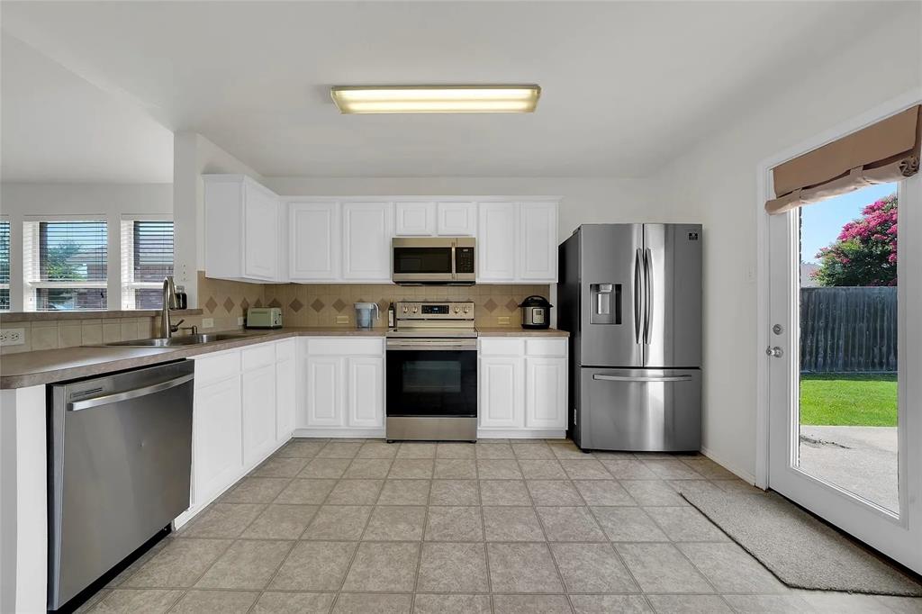 713 Baldwin Road Wylie, TX 75098 - Photo 8 of 29 a kitchen with a refrigerator a stove top oven a sink and dishwasher
