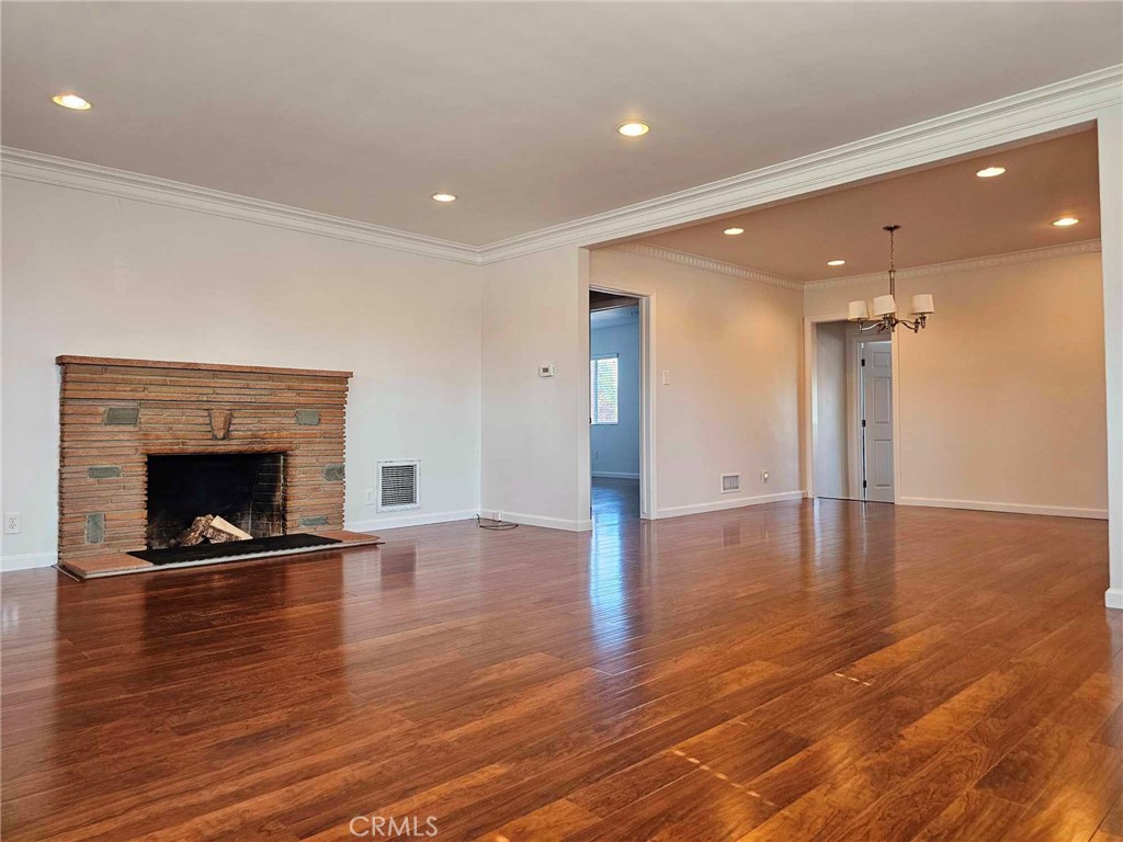 5259 Angeles Vista Boulevard View Park, CA 90043 - Photo 15 of 42 a view of an empty room with wooden floor a fireplace