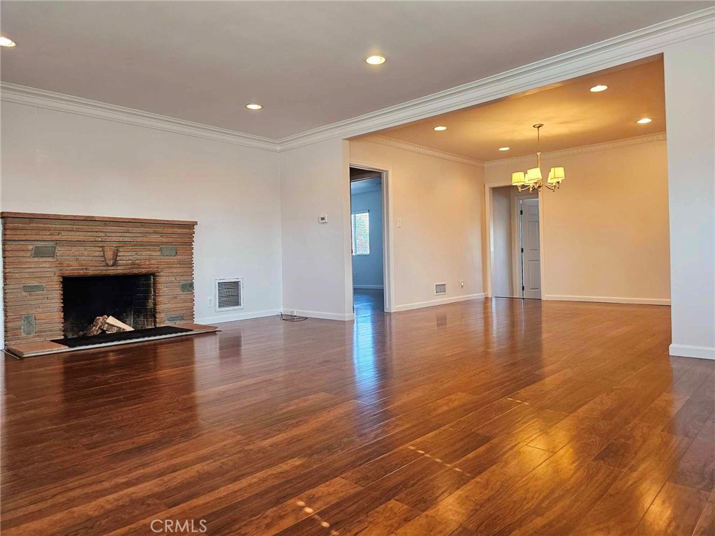 5259 Angeles Vista Boulevard View Park, CA 90043 - Photo 16 of 42 a view of an empty room with wooden floor and a fireplace