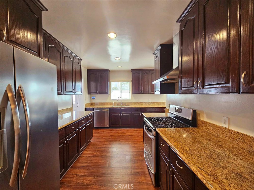 5259 Angeles Vista Boulevard View Park, CA 90043 - Photo 20 of 42 a kitchen with stainless steel appliances granite countertop a sink a stove and a refrigerator