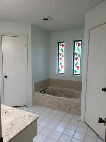 a bathroom with a tub a window and a shower