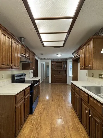 a large kitchen with stainless steel appliances granite countertop a stove a sink dishwasher and a refrigerator