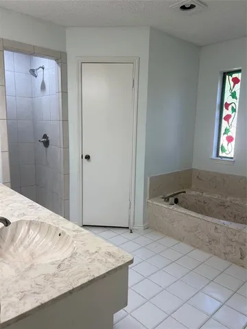 a spacious bathroom with a granite countertop sink a mirror and a shower