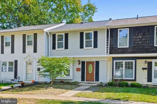 a front view of a house with a yard and potted plants
