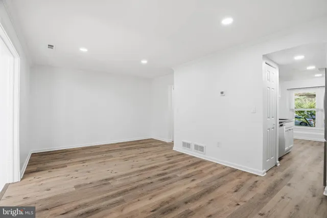 an empty room with wooden floor and entrance