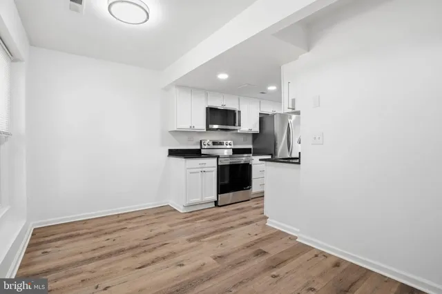 a kitchen with granite countertop a refrigerator and a stove top oven