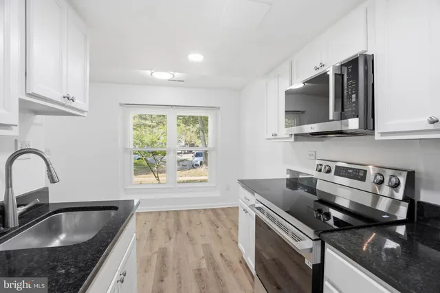 a kitchen with a stove a sink and a microwave