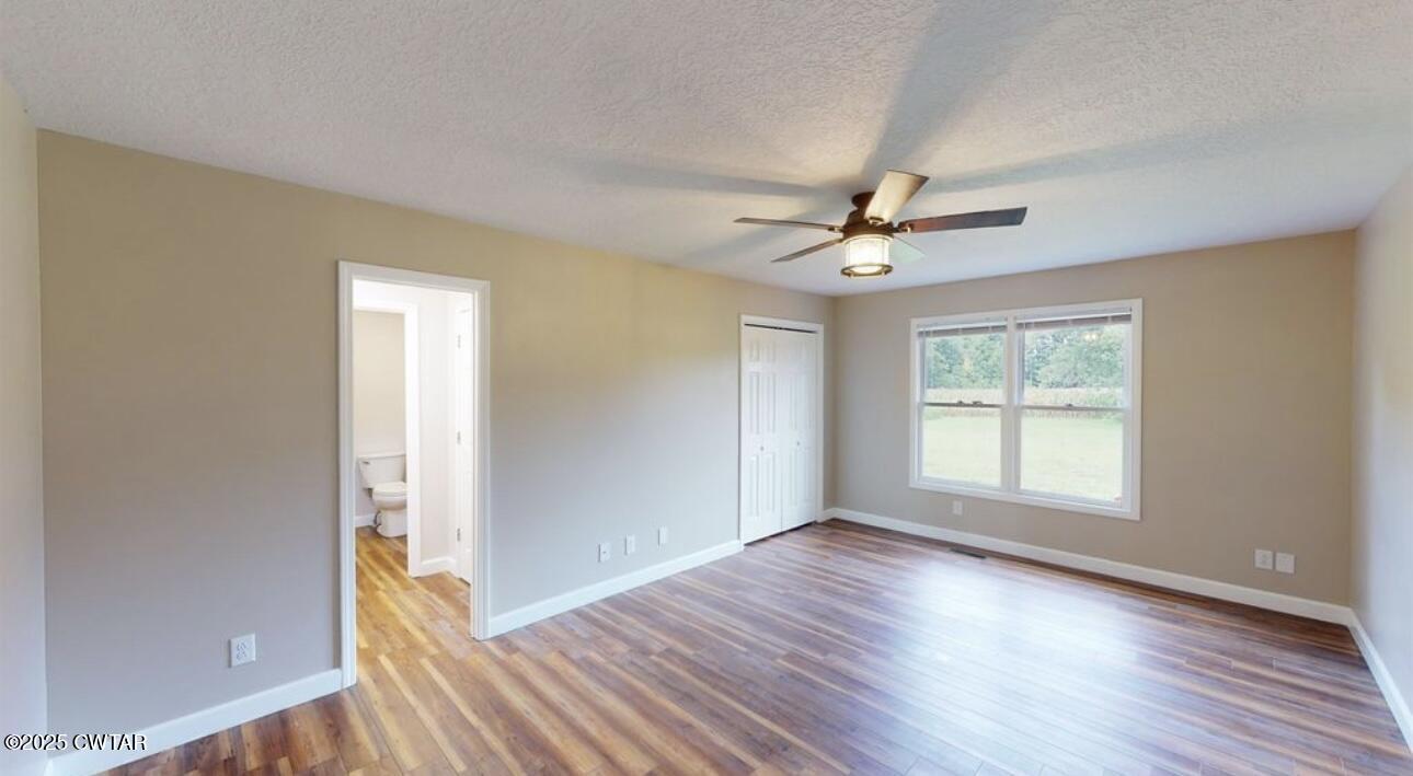 40 J D Barr Road Milan, TN 38358 - Photo 14 of 28 an empty room with wooden floor and windows