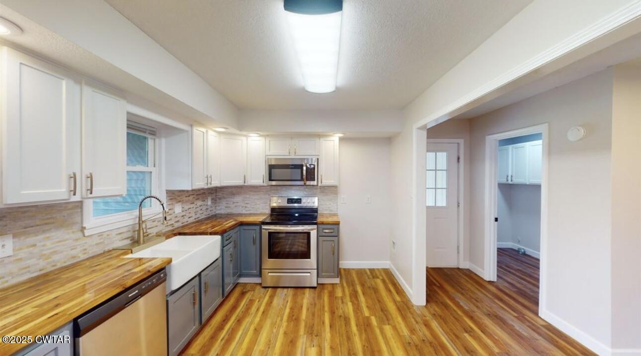 40 J D Barr Road Milan, TN 38358 - Photo 5 of 28 a kitchen with wooden floor and stainless steel appliances