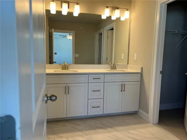 a spacious bathroom with a double vanity sink mirror and shower