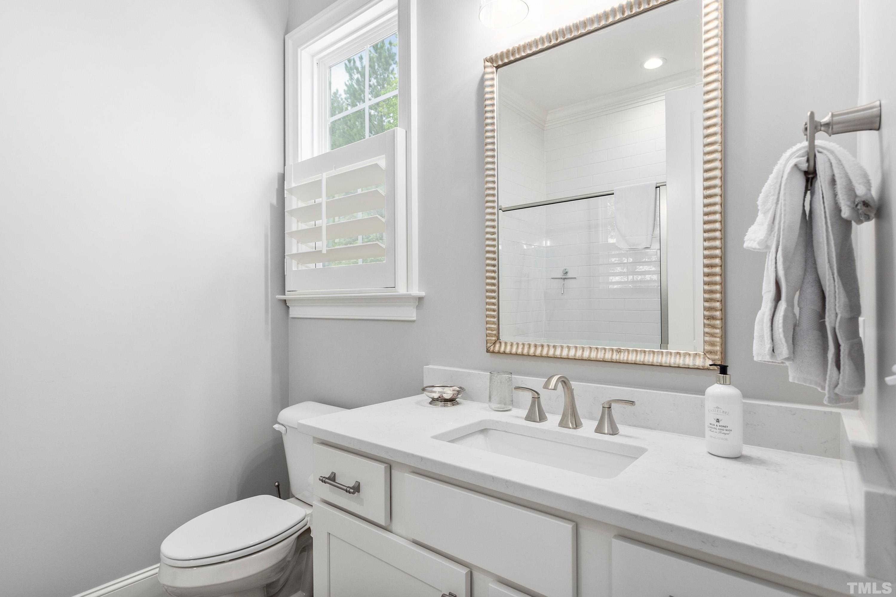 3013 Colmar Manor Drive Cary, NC 27519 - Photo 25 of 53 a bathroom with a sink vanity granite toilet and a mirror