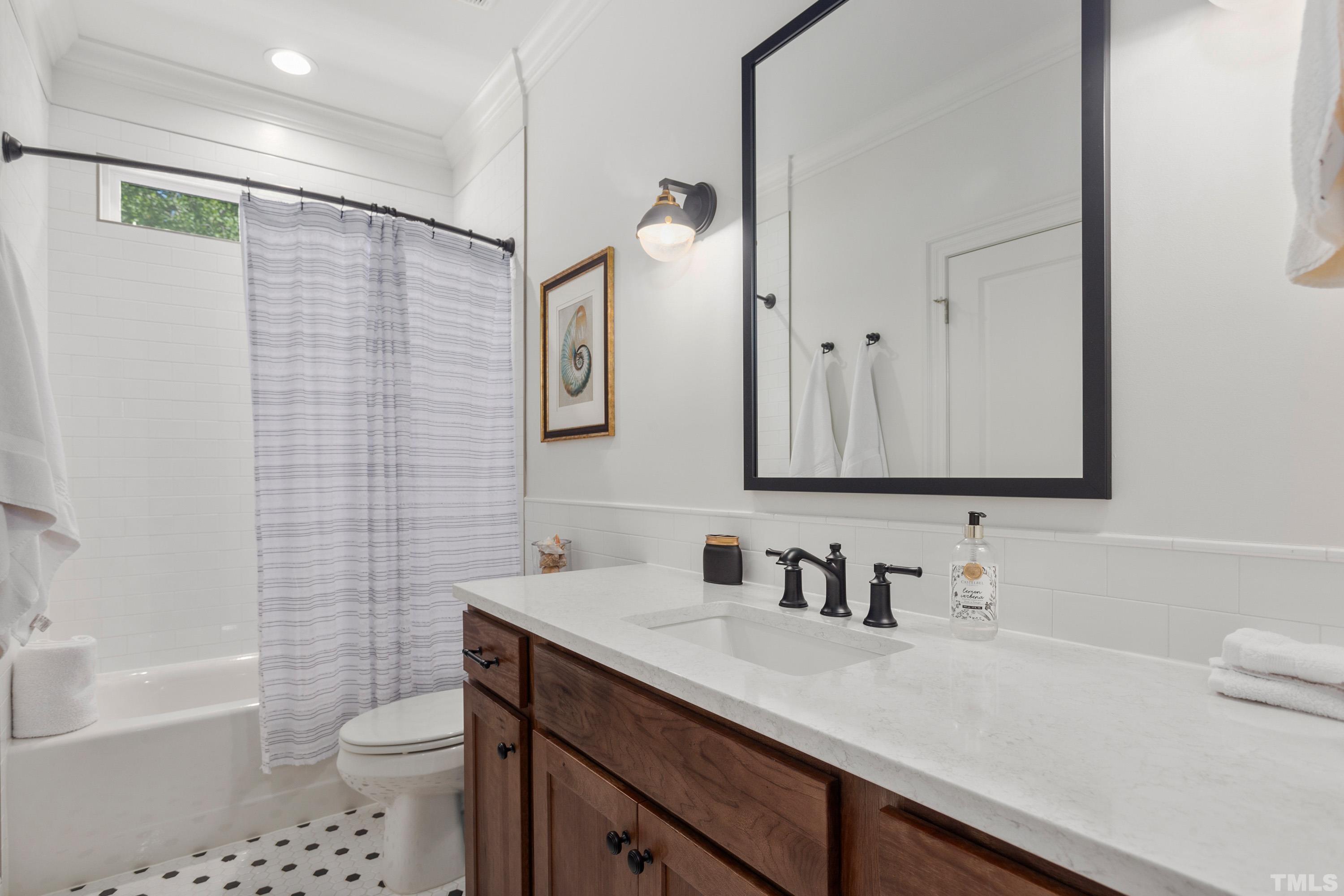 3013 Colmar Manor Drive Cary, NC 27519 - Photo 37 of 53 a bathroom with a sink a toilet a mirror a vanity and bathtub
