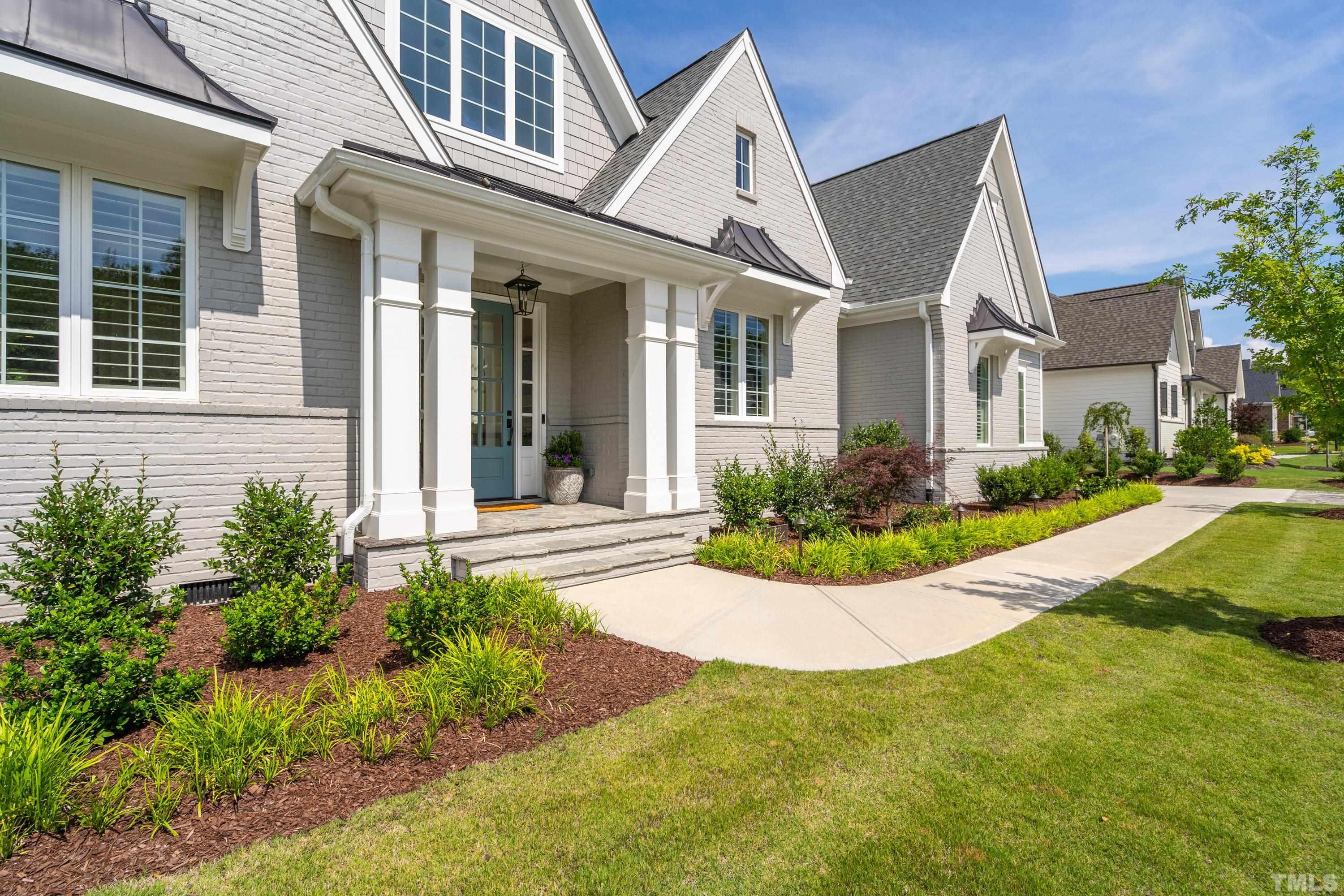 3013 Colmar Manor Drive Cary, NC 27519 - Photo 48 of 53 a view of a white house next to a yard with potted plants