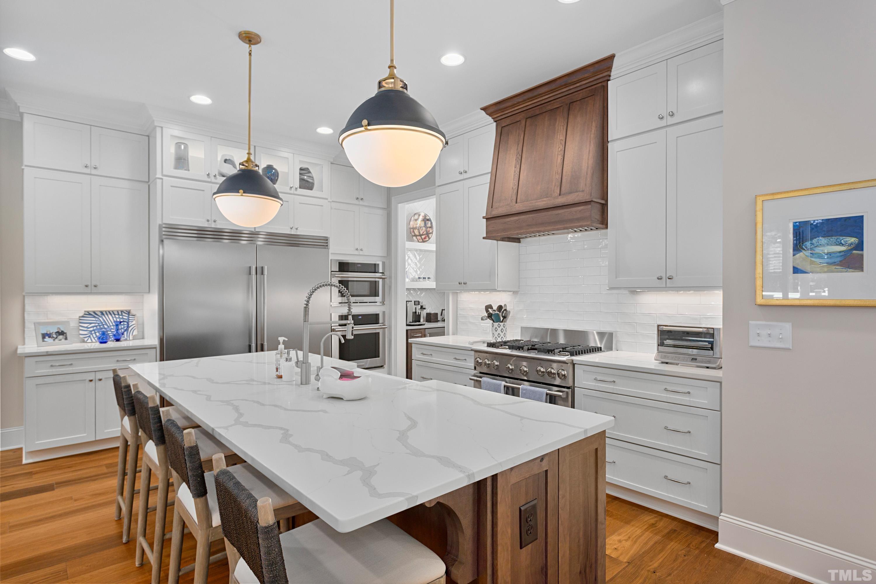 3013 Colmar Manor Drive Cary, NC 27519 - Photo 8 of 53 a kitchen with a table chairs and white cabinets
