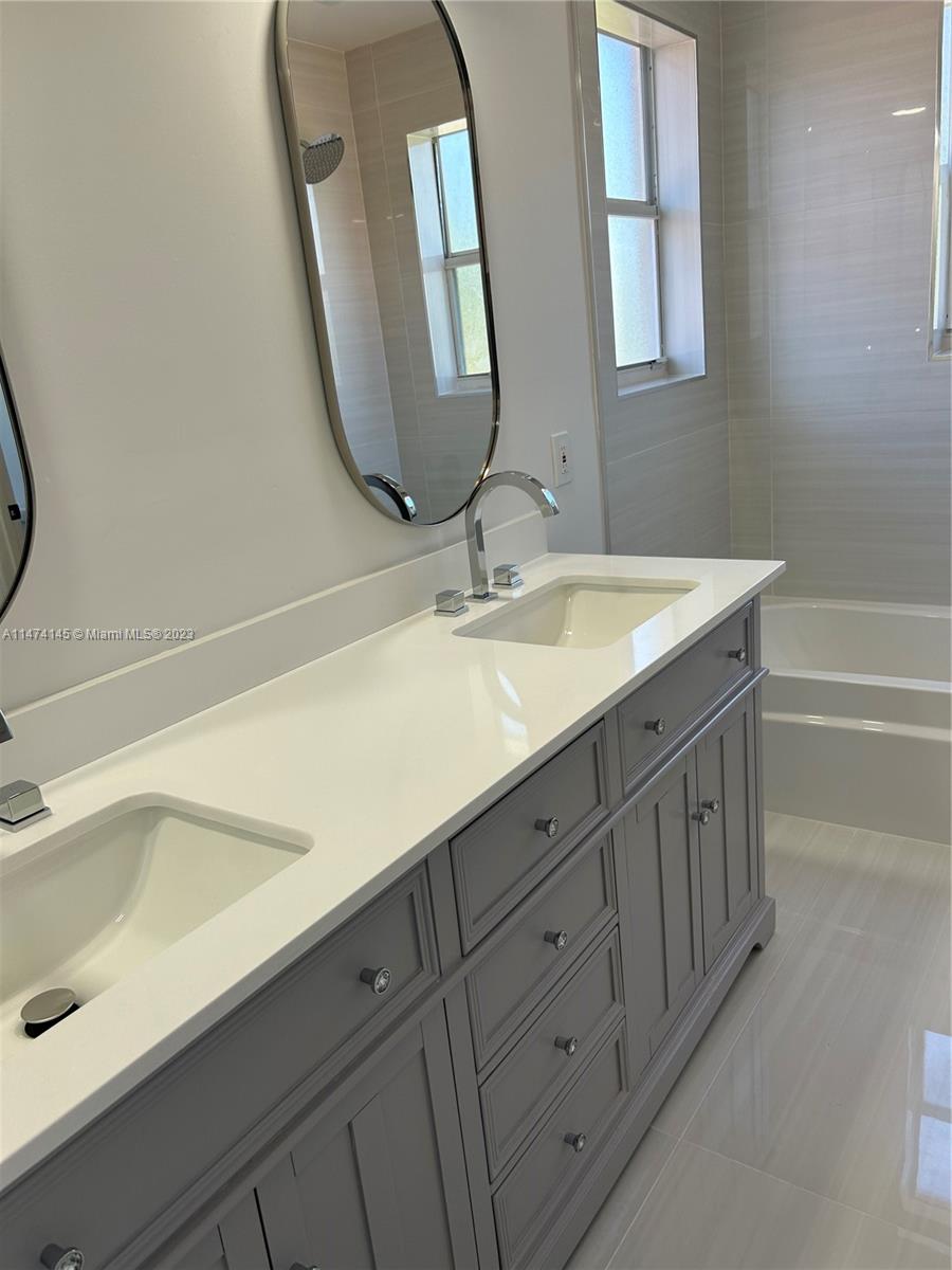 Three Lakes Miami, FL 33186 - Photo 16 of 32 a bathroom with a double vanity sink and a mirror