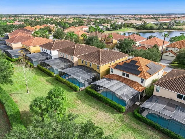 an aerial view of residential houses with outdoor space and trees